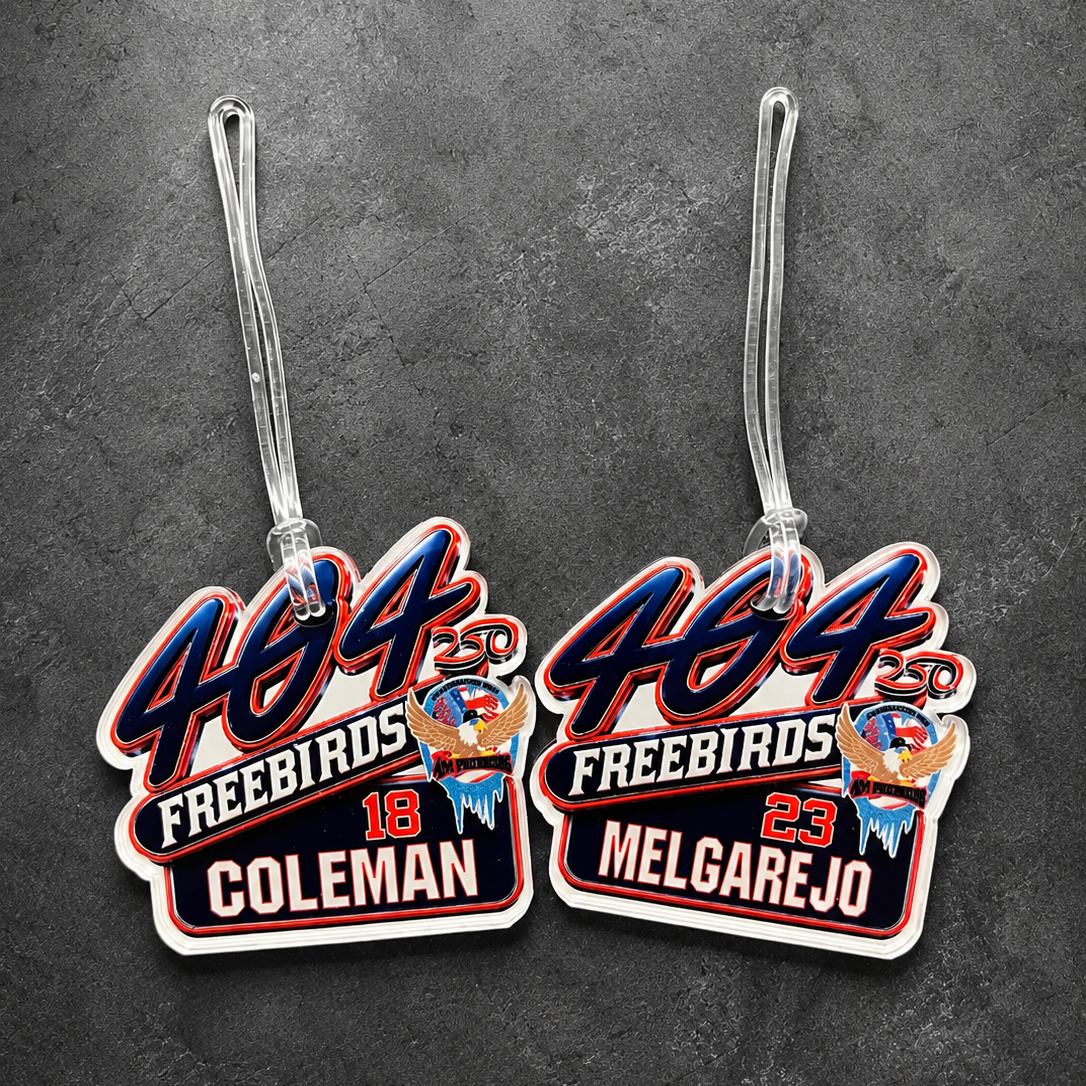 Two luggage tags with '484 Freebirds' branding on a dark gray background